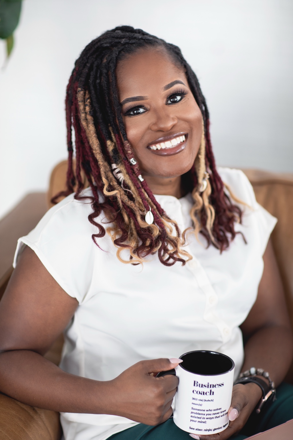 Yvette Howard, LCSW, holding her Business Coach mug